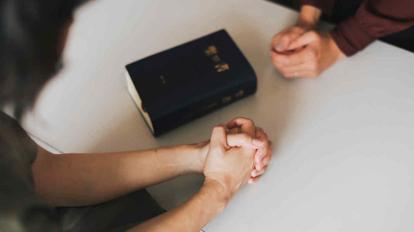 two japanese women praying with bible